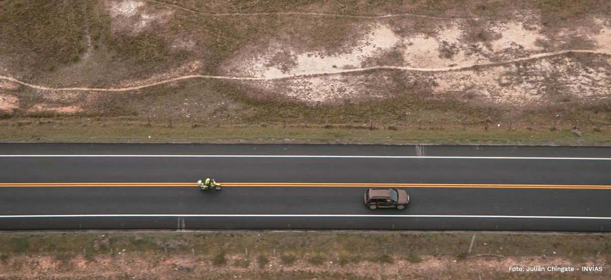 Fotografía de vehículo y motocicleta de la Policía Nacional atravesando parte de la troncal del Magdalena Medio.