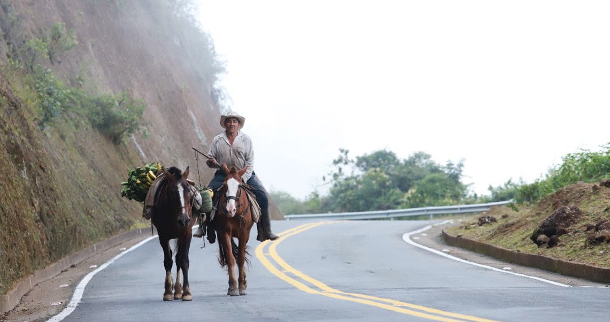 Fotografía campesino en su caballo transitando por la vía.