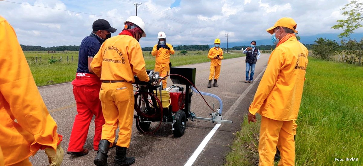 Fotografía de trabajadores del INVÍAS en labores de demarcación de vías con equipos de propulsión manual.
