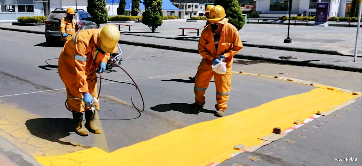 Fotografía de trabajadores del INVÍAS realizando labores de demarcación de vías.