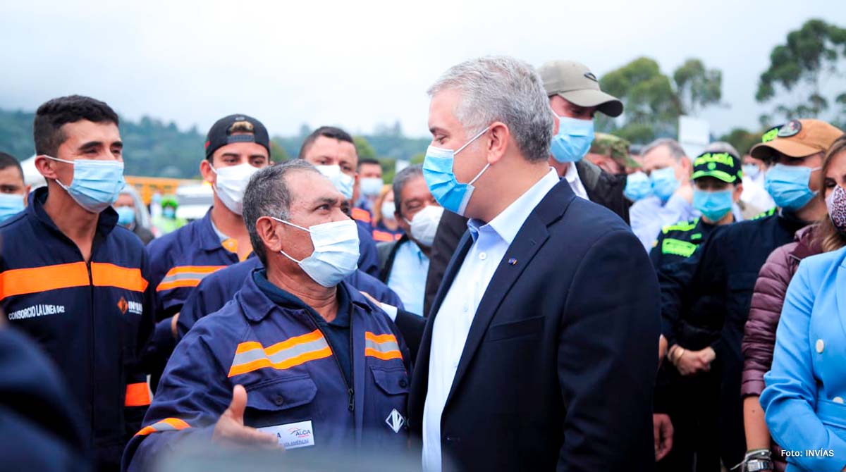 Fotografía del presidente de La República, Iván Duque Márquez, dando la mano a uno de los trabajadores que hicieron posible el Cruce de la Cordillera Central.