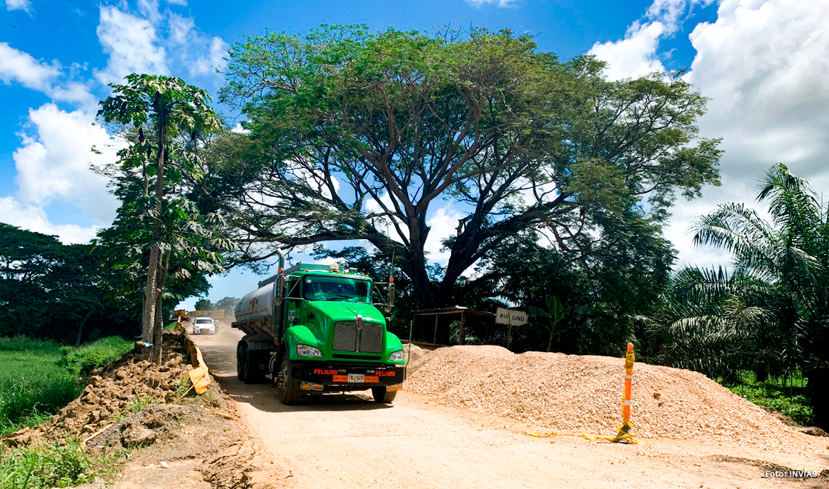 Fotografía del tránsito de vehículos por vía en construcción de la zona.