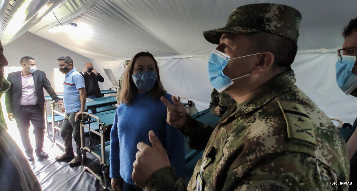 Fotografía de la Secretaria General del INVÍAS, Catalina Téllez Posada junto a miembros de las fuerzas militares durante la entrega de las carpas de despliegue rápido.