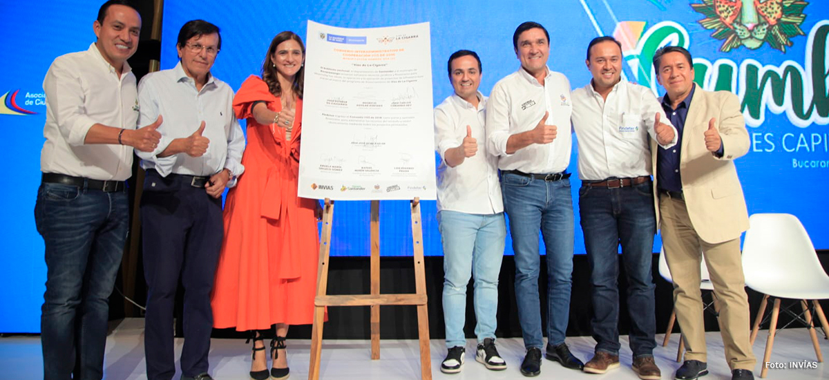 Fotografía de la Ministra de Transporte, Ángela María Orozco y del Director General del INVÍAS, Juan Esteban Gil; y algunos protagonistas junto al convenio del programa Vías de La Cigarra.