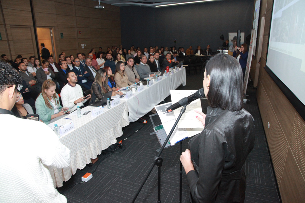 Fotografía de la presentadora del evento y el público de la 7ª Rueda de Innovación y Sostenibilidad.