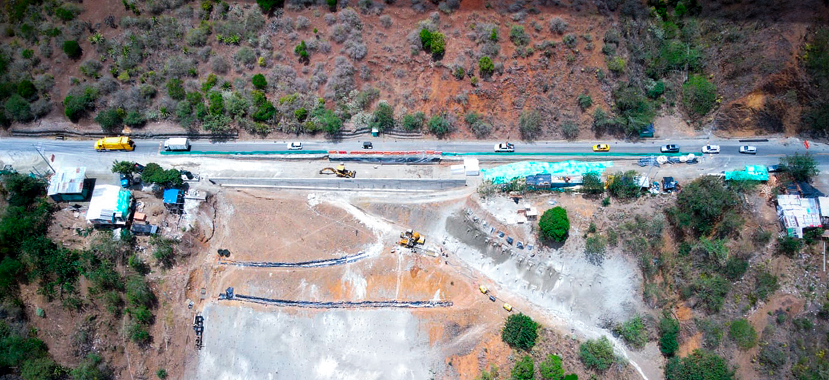Fotografía aérea de proceso de construcción de carreteras y tránsito vehícular en vía nacional.