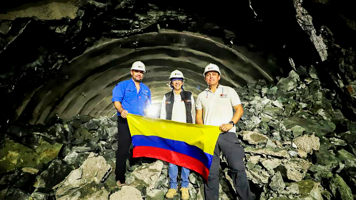 Fotografía de la Directora General del INVÍAS izando la bandera de Colombia junto al personal a su cargo en el cale en el túnel Guillermo Gaviria Echeverri.