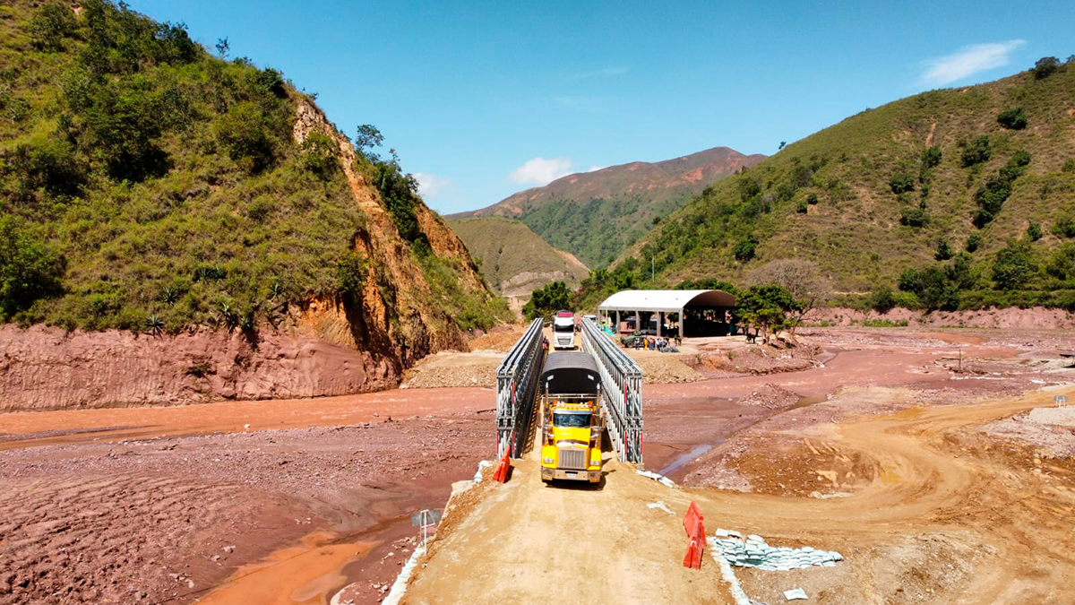 Fotografía del paso de vehículos de carga por el puente metálico provisional en el sector El Tarrita del corredor Ocaña - Cúcuta.