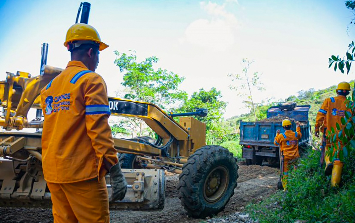 Fotografía de colaboradores del INVÍAS junto a maquinaria pesada que hace parte de los trabajos de construcción de vías del proyecto piloto del programa Caminos Comunitarios de la Paz Total.