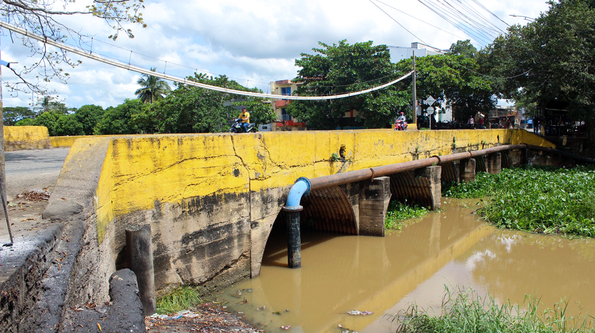 Fotografía lateral del puente sobre el caño Chimalito, en Lorica, Córdoba, mientras transitan los usuarios de la vía.