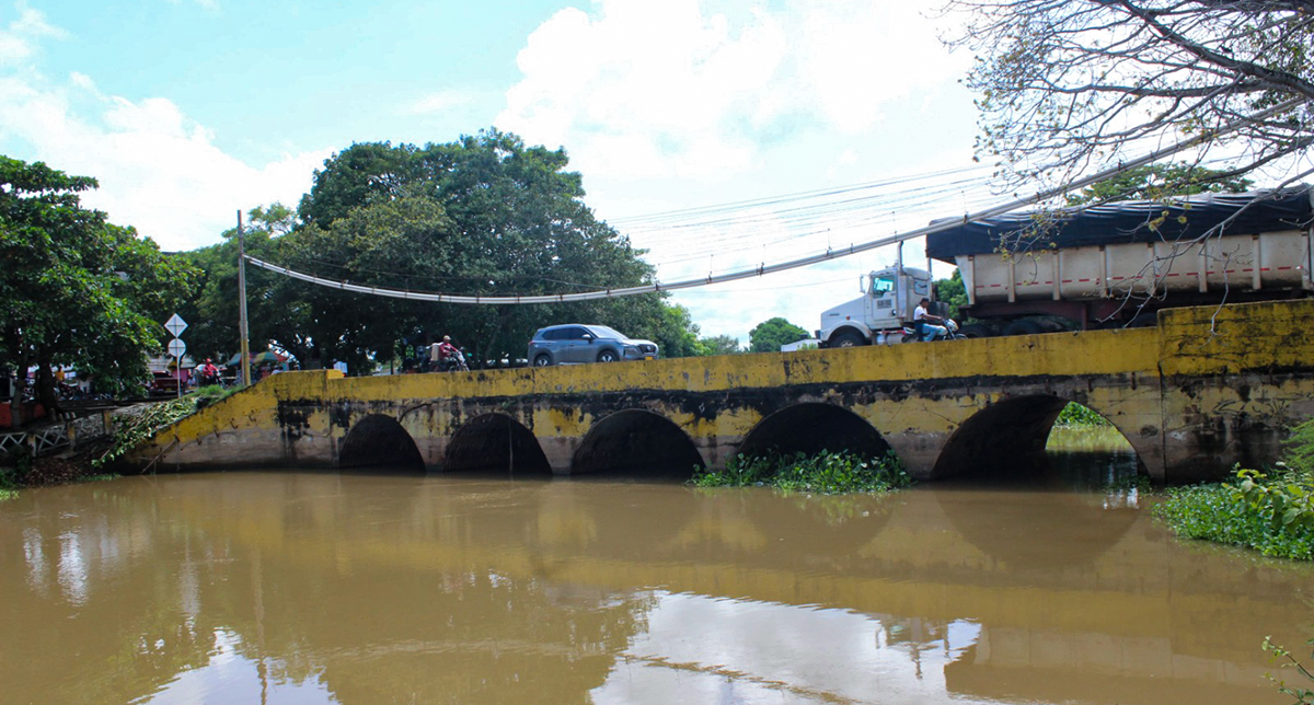Fotografía lateral del puente sobre el caño Chimalito, en Lorica, Córdoba, mientras transitan los usuarios de la vía.