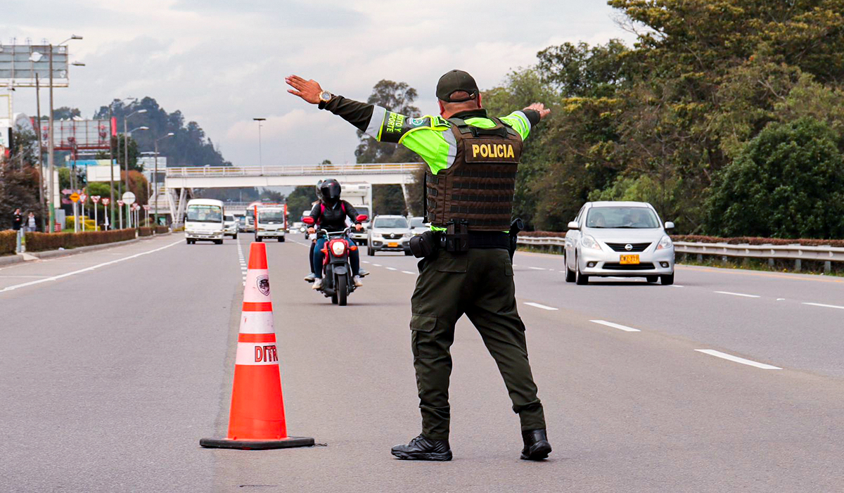 Fotografía de agente de tránsito en sus labores de direccionamiento del tráfico en vía del país.