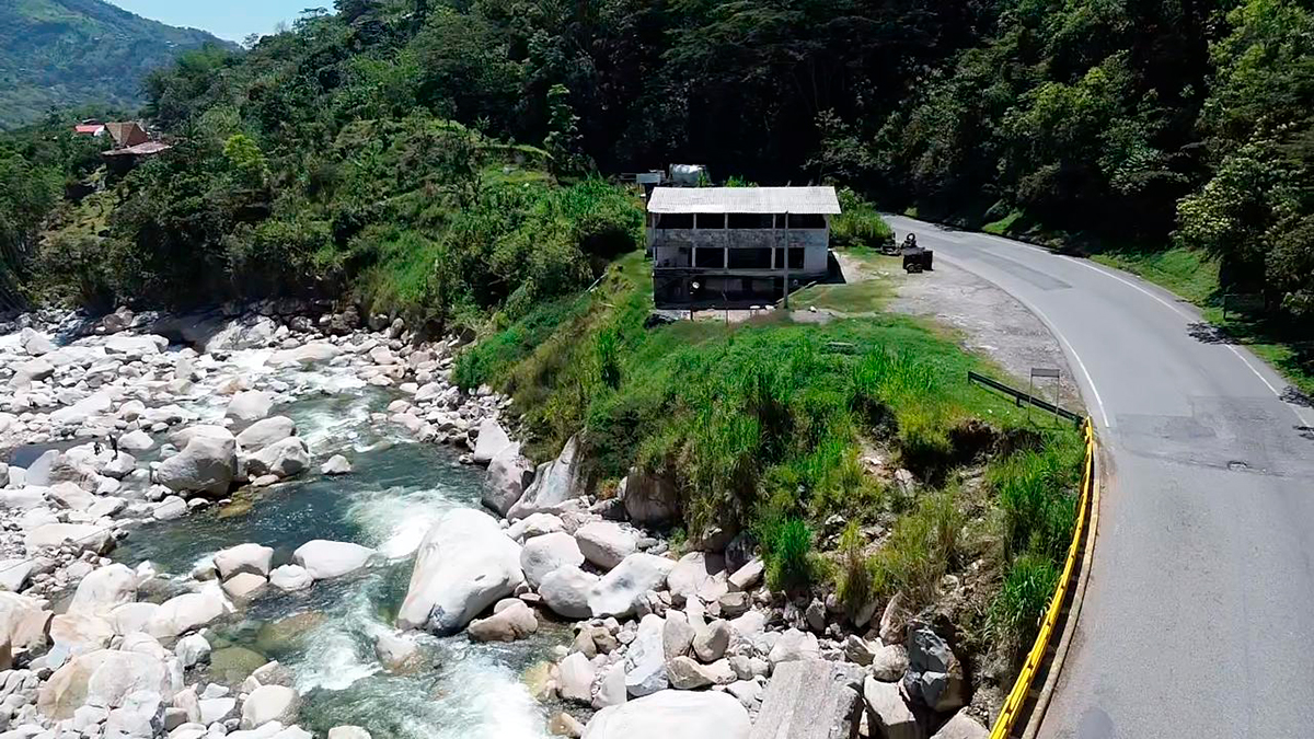 Fotografía de casa situada junto al puente vehicular sobre el río Cocorná, Antioquia.