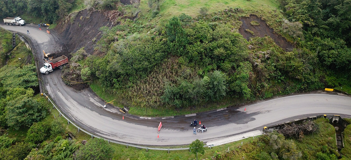 Fotografía aérea de colaboradores del Invías operando maquinaria pesada en labores de atención vial en cara de montaña que hace parte de la Transversal del Carare.