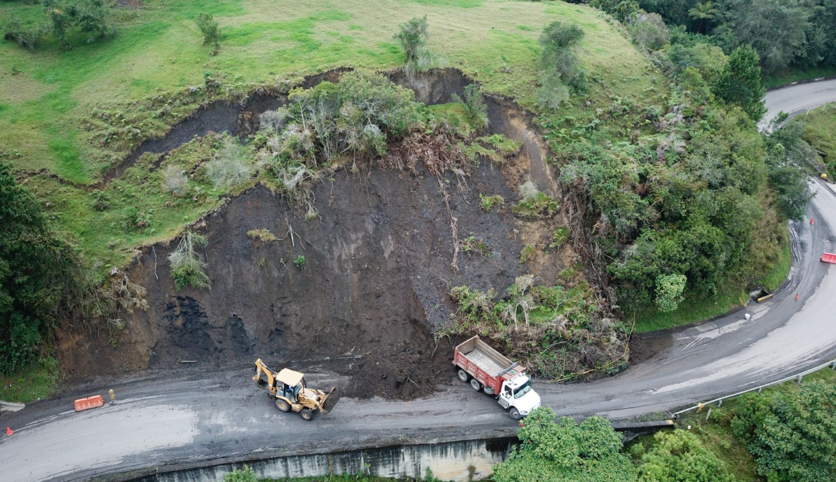 Fotografía aérea de colaboradores del Invías operando maquinaria pesada en labores de atención vial en cara de montaña que hace parte de la Transversal del Carare.