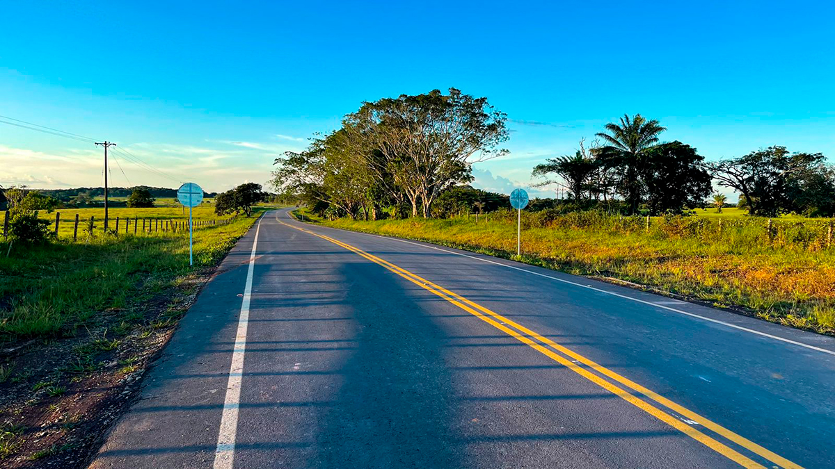 Fotografía de vía en Colombia junto a un paisaje rural.