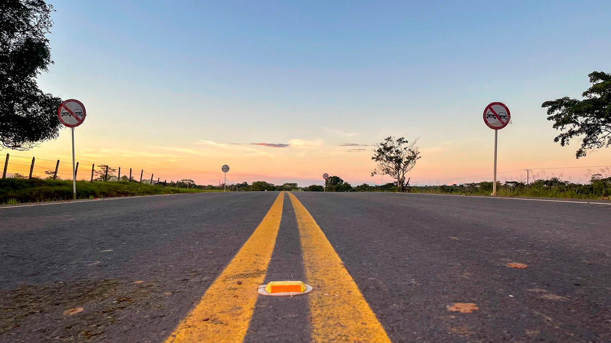 Fotografía desde el suelo en vía en Colombia al fondo atardecer.