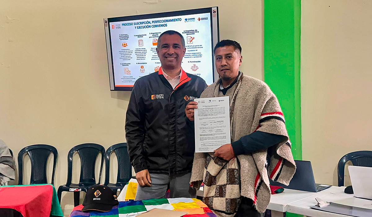 Fotografía de firma del director General del Invías, Juan Carlos Montenegro Arjona y de beneficiario de obras del programa Caminos Comunitarios de la Paz Total en Nariño.