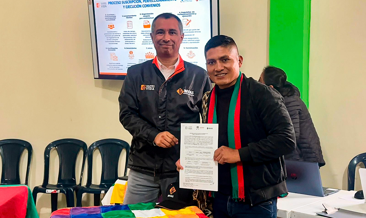 Fotografía de firma del director General del Invías, Juan Carlos Montenegro Arjona y de beneficiario de obras del programa Caminos Comunitarios de la Paz Total en Nariño.