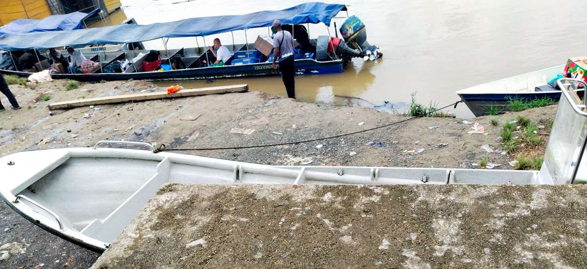 Fotografía de embarcación mediana con pasajeros en el muelle fluvial sobre el río Atrato en Murindó, Antioquia que muestra el estado actual.